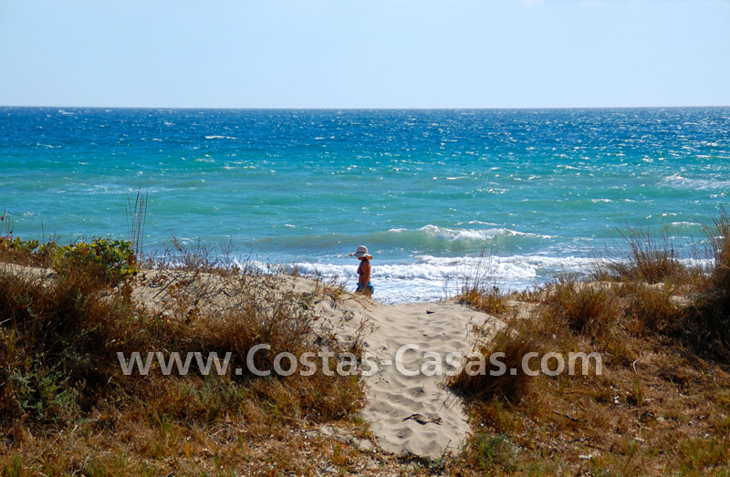 Marbella: meisje met hoed op het strand by Costas & Casas